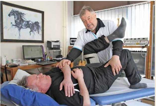 Fysioterapeutti Bengt Kevin venyttää itse kehittämällään työkalulla Jouko Huidan lonkan pehmytkudoksia, jotta nivelkapseliin saadaan lisää tilaa. Yksinkertaista mutta tehokasta.